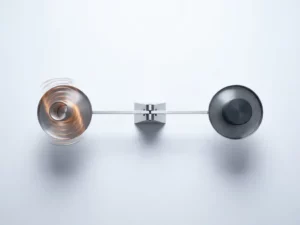 Mechanical scale in perfect balance with glowing amber spring on left side and matte charcoal counterweight on right against white background