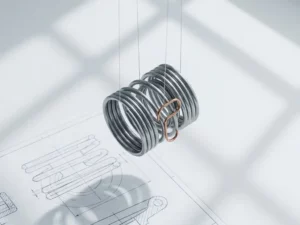 Polished steel spring mechanism suspended above white engineering workbench with technical drawing and copper accent detail