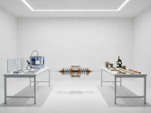 Precision spring mechanism suspended between two workbenches with prototyping tools and traditional engineering instruments in white laboratory
